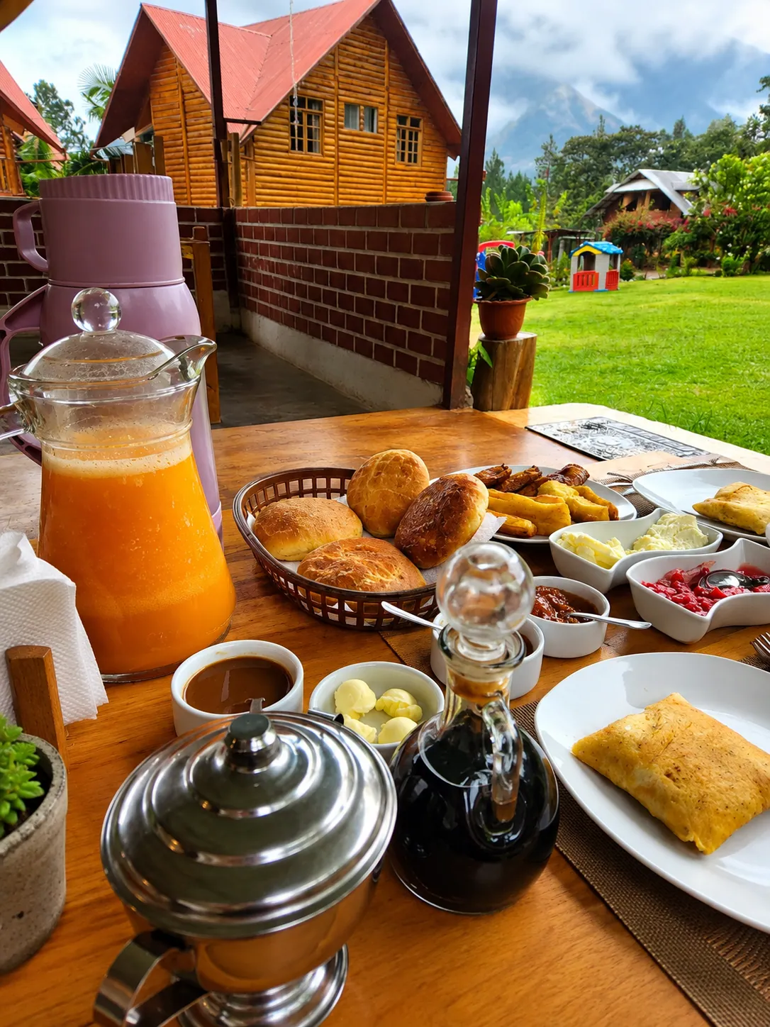 Desayuno incluido servido frente al jardín y las cabañas de Elfen