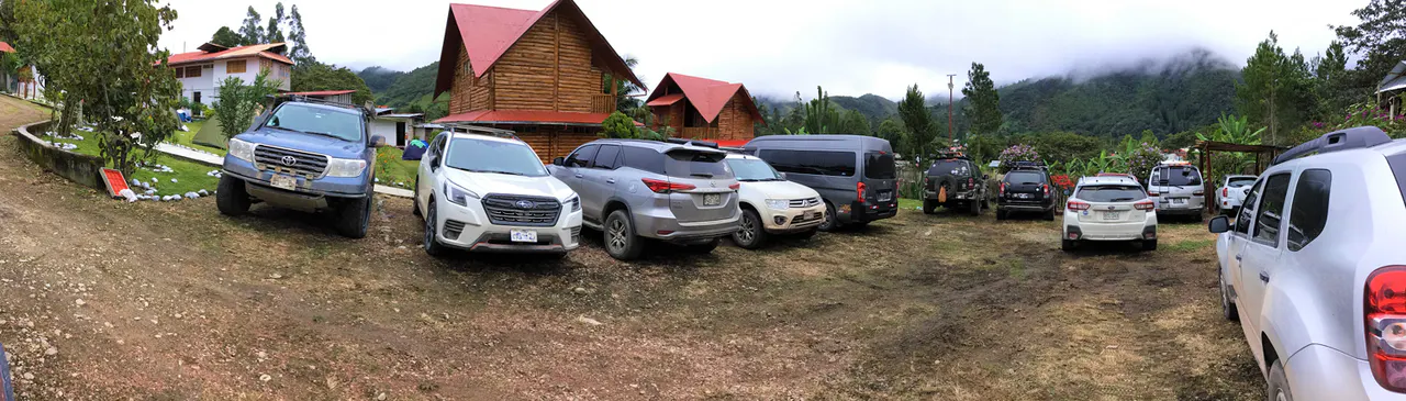 Estacionamiento real de Elfen con vehículos, cabañas y montañas